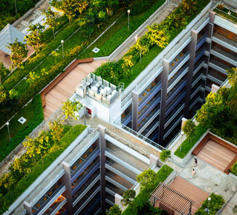 A green rooftop on a multi-storey car park with trees and benches for public use.