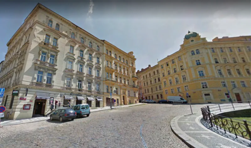 Rows of mid-rise buildings lining a wide residential cobblestone street.